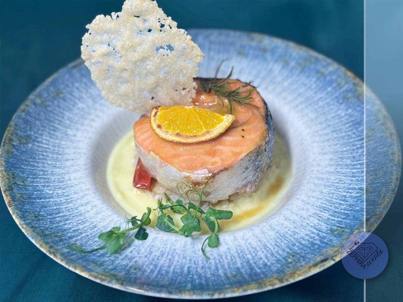 Somon cu cremă fină, chips crocant și felie de portocală