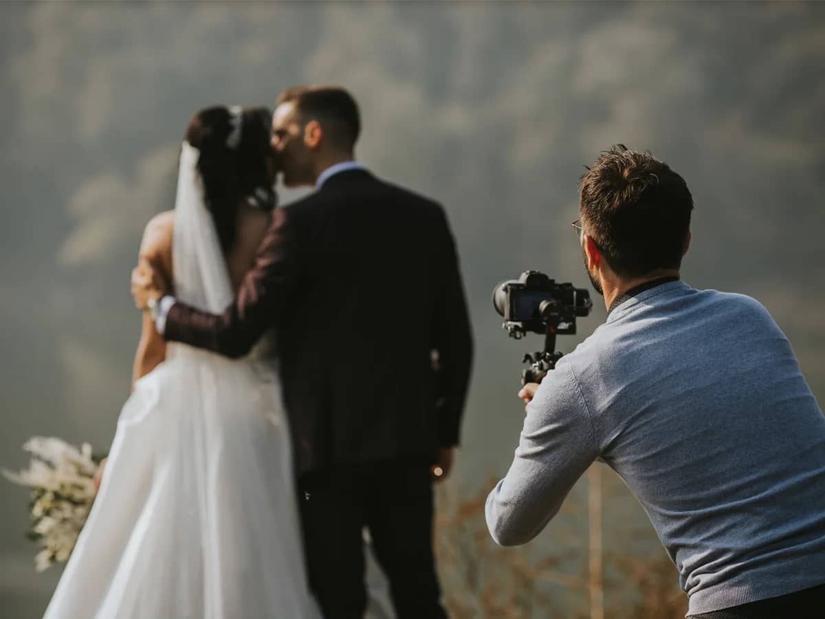 Videograf profesionist filmând mirii în timpul ședinței de nuntă