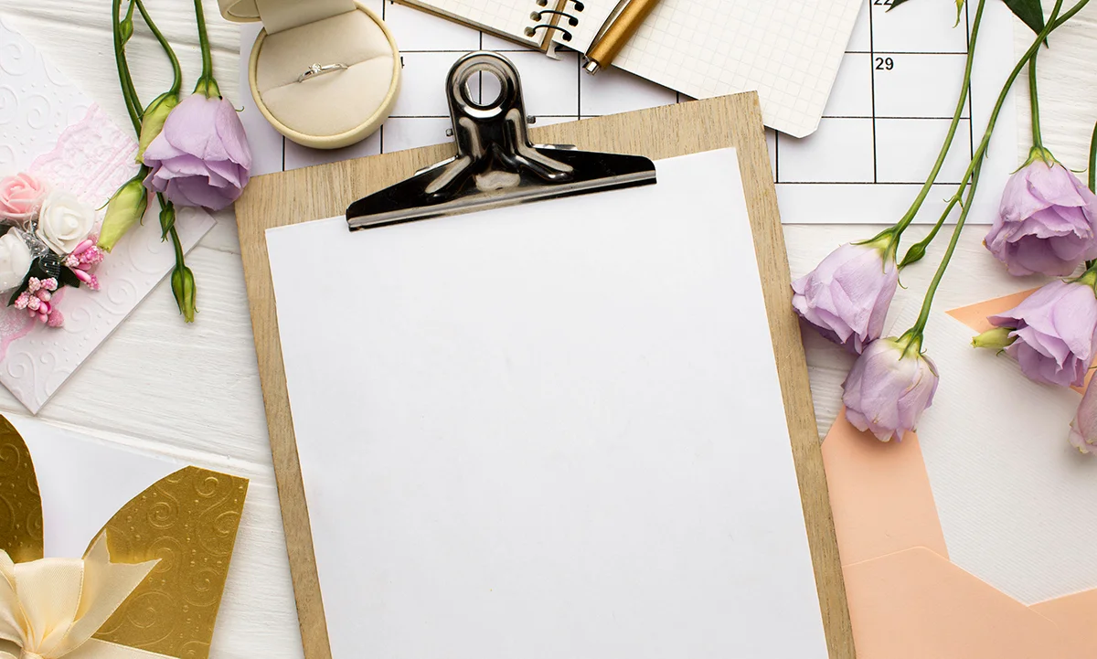 Calendar, agendă, verighetă și flori folosite pentru planificarea nunții